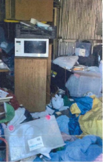Pile of microwave, white goods and rubbish stacked in the yard